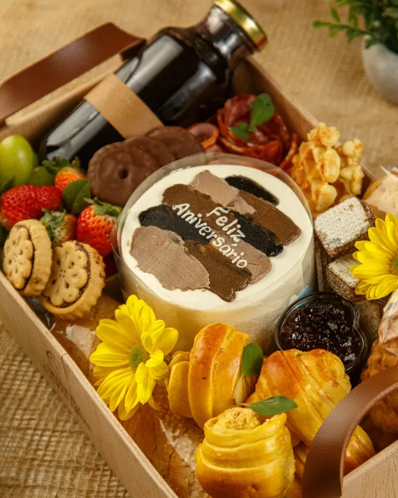 Detalhe da cesta Morning Elegance com bolo de aniversário, frutas, biscoitos e pães